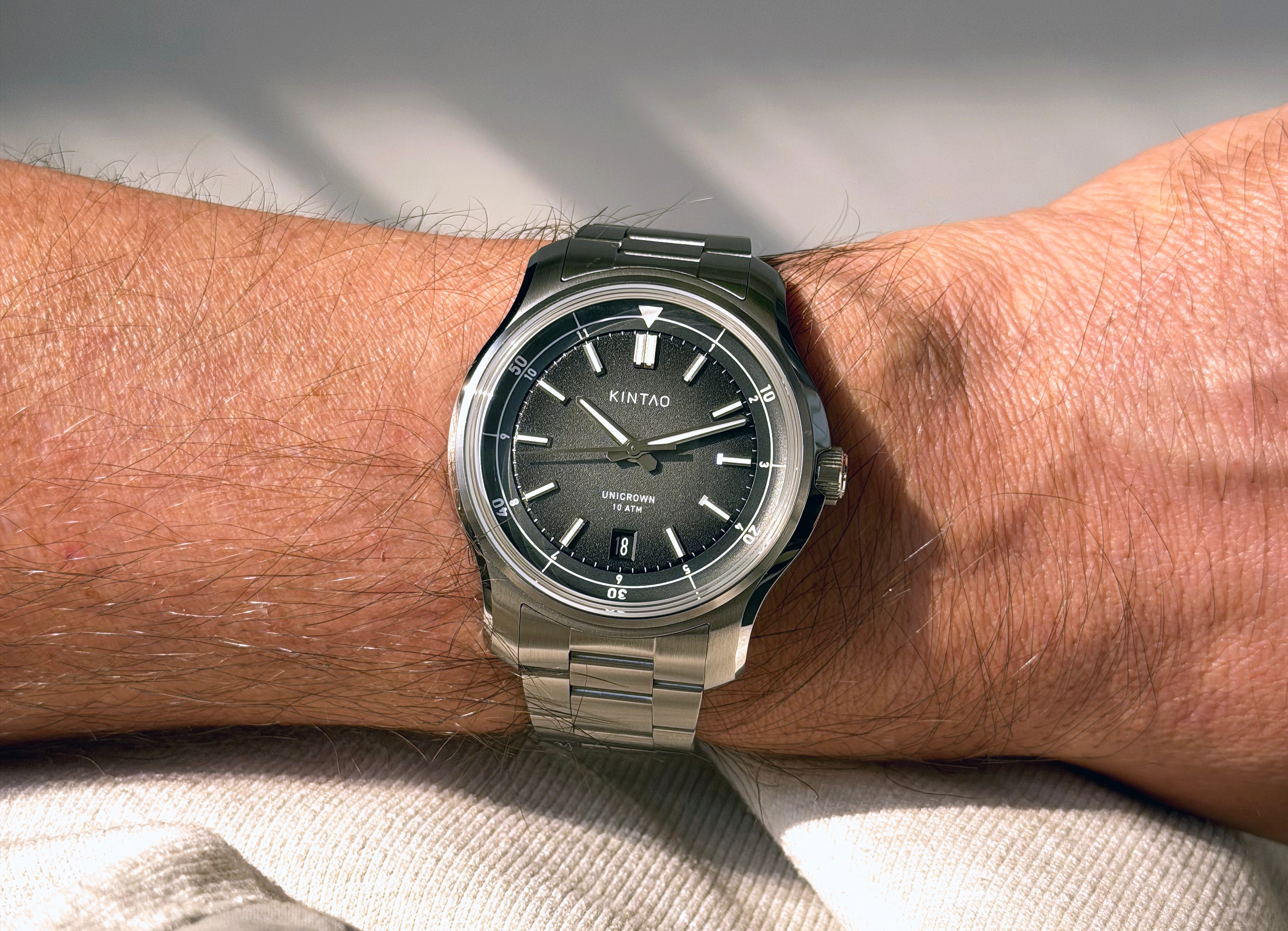 Charcoal UC1 Recurve on its steel bracelet, worn on the wrist in sunlight