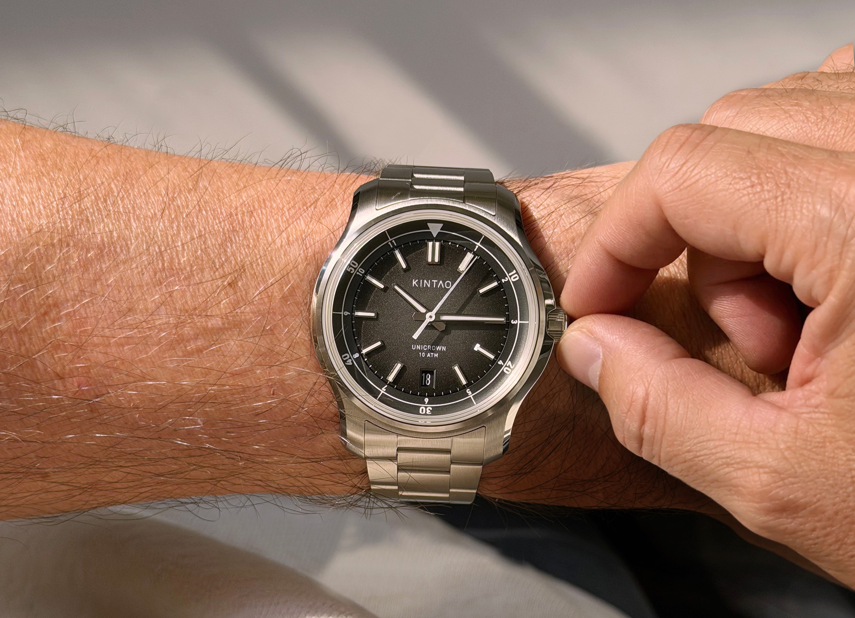 Charcoal UC1 Recurve on the wrist, with fingers holding the Unicrown crown